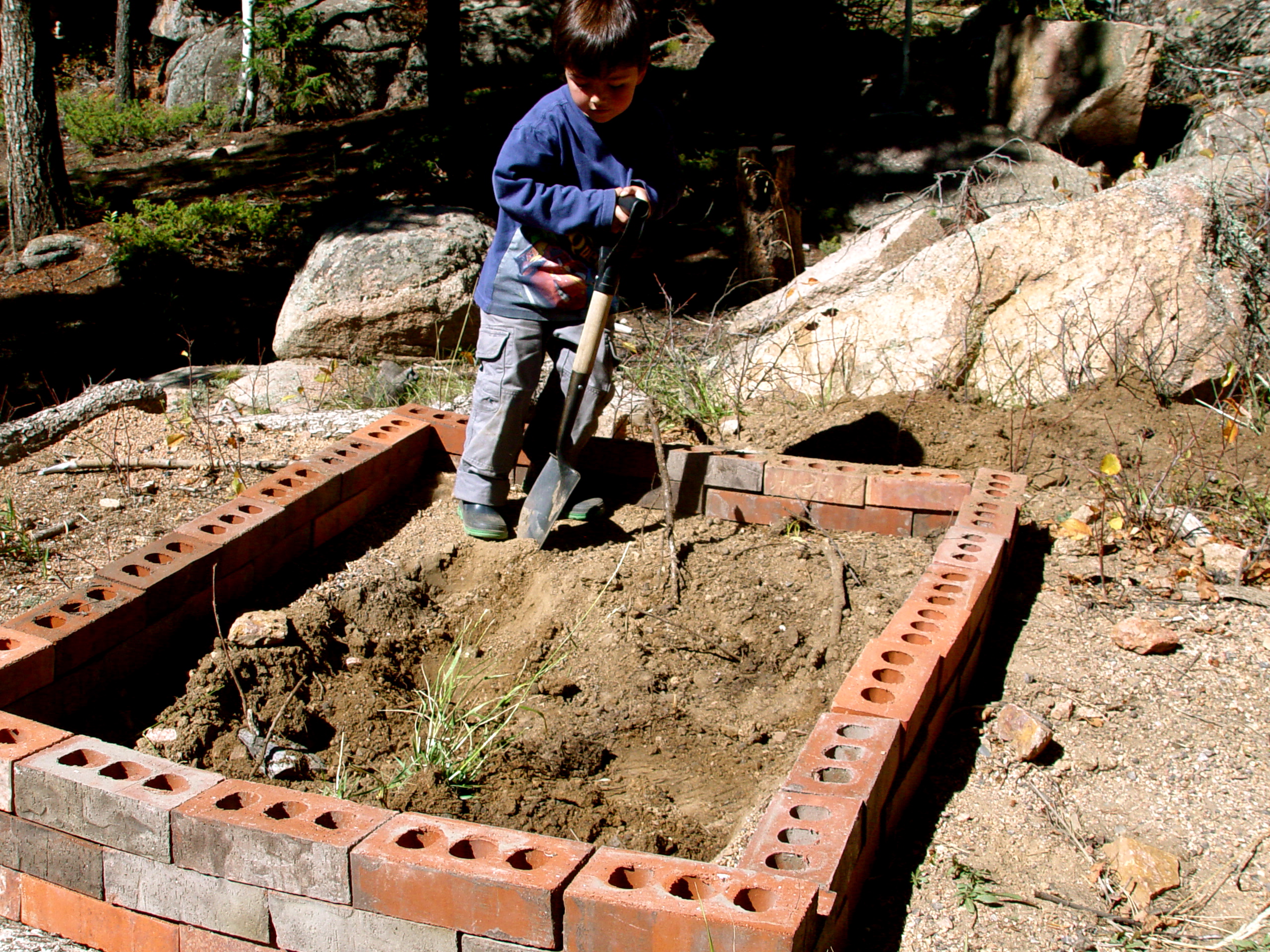 building a raised bed made from bricks on a small suburban homestead